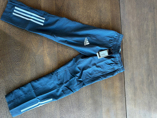 Blue Adidas pants with white stripes on a wooden surface