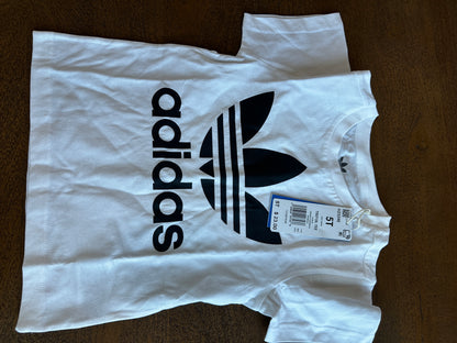 White Adidas t-shirt with a tag on a brown surface